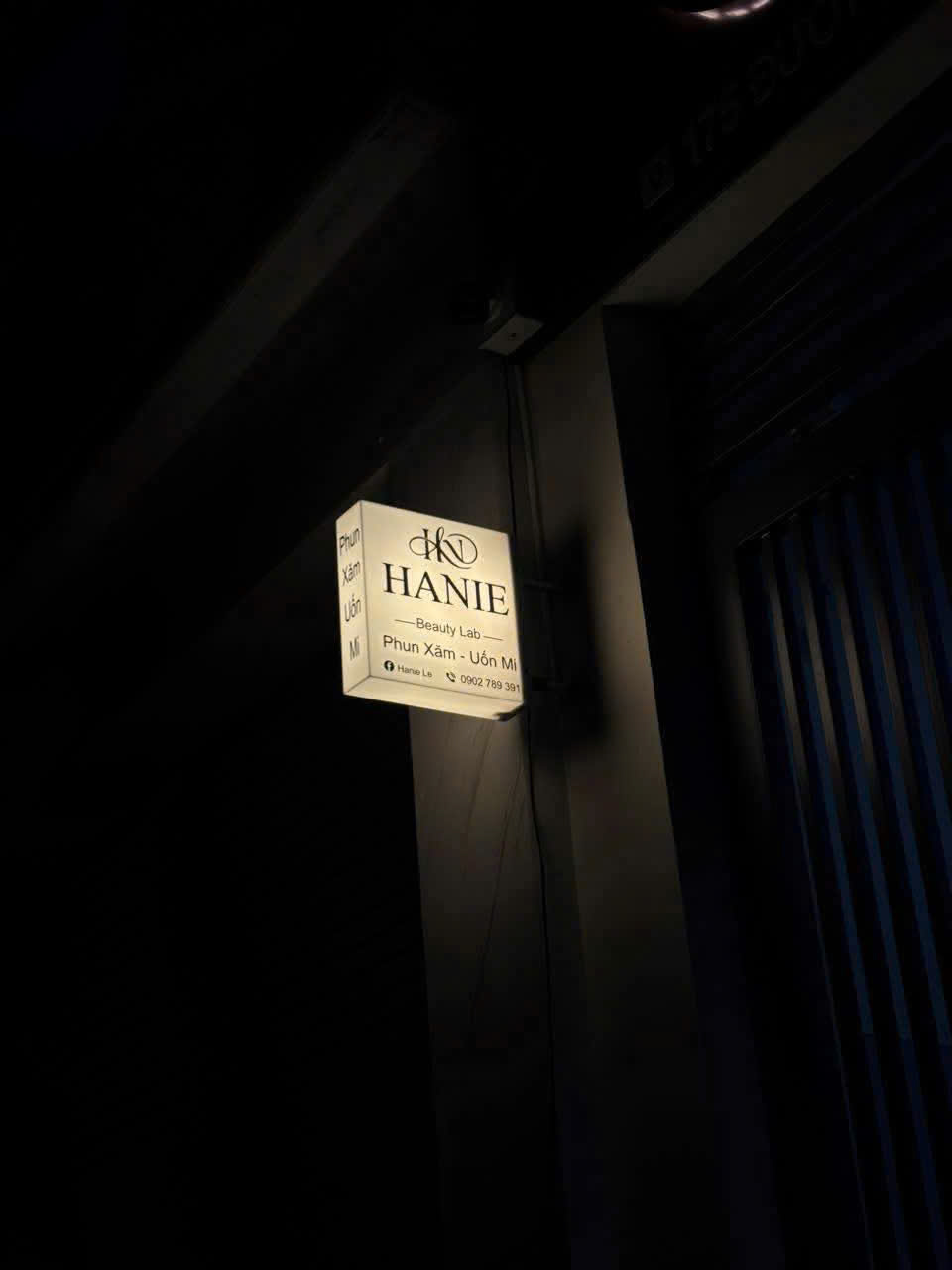 Hanie Beauty Lab — hộp đèn lắp tường khi bật sáng ban đêm.
